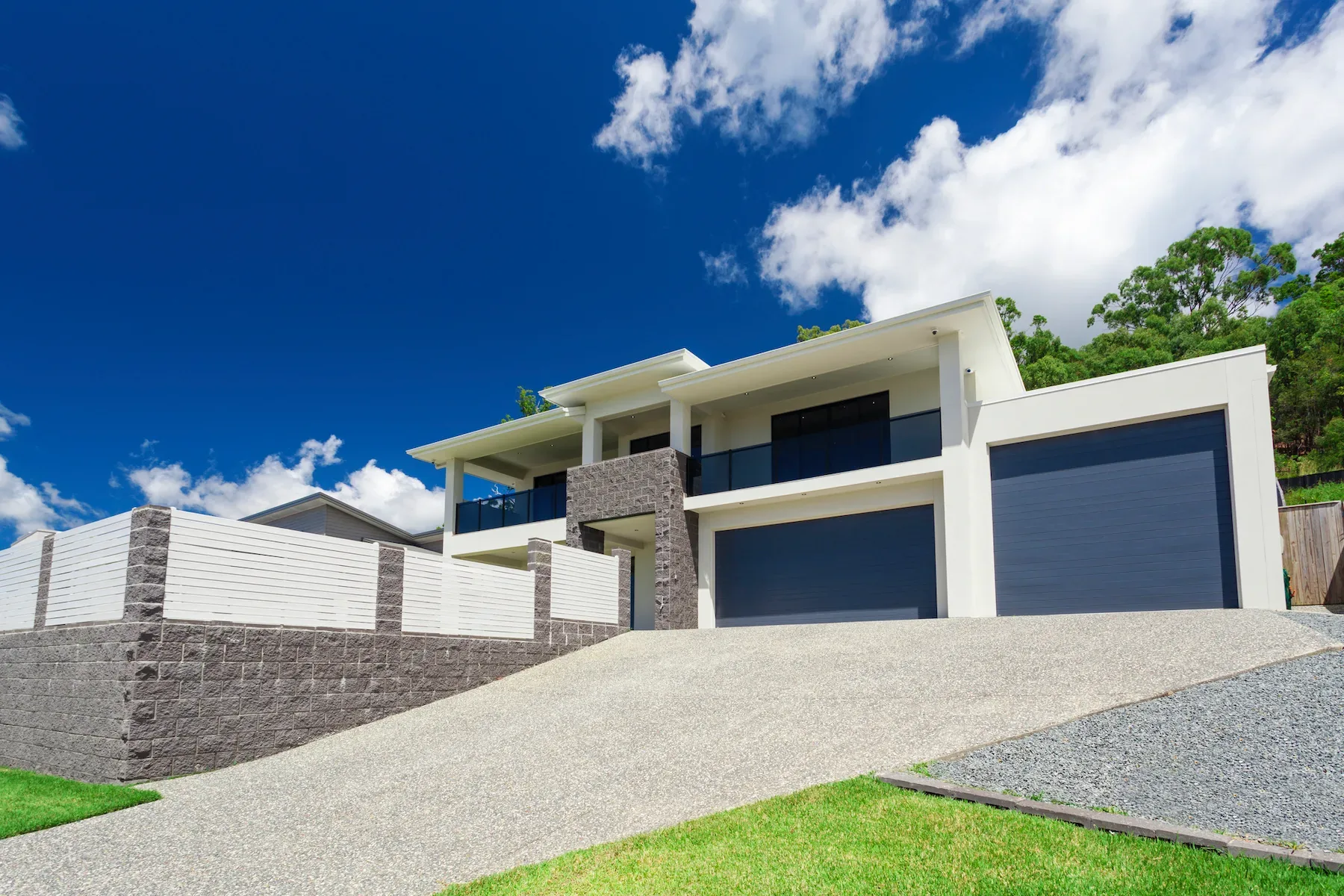 White multi-level home with aggregate driveway