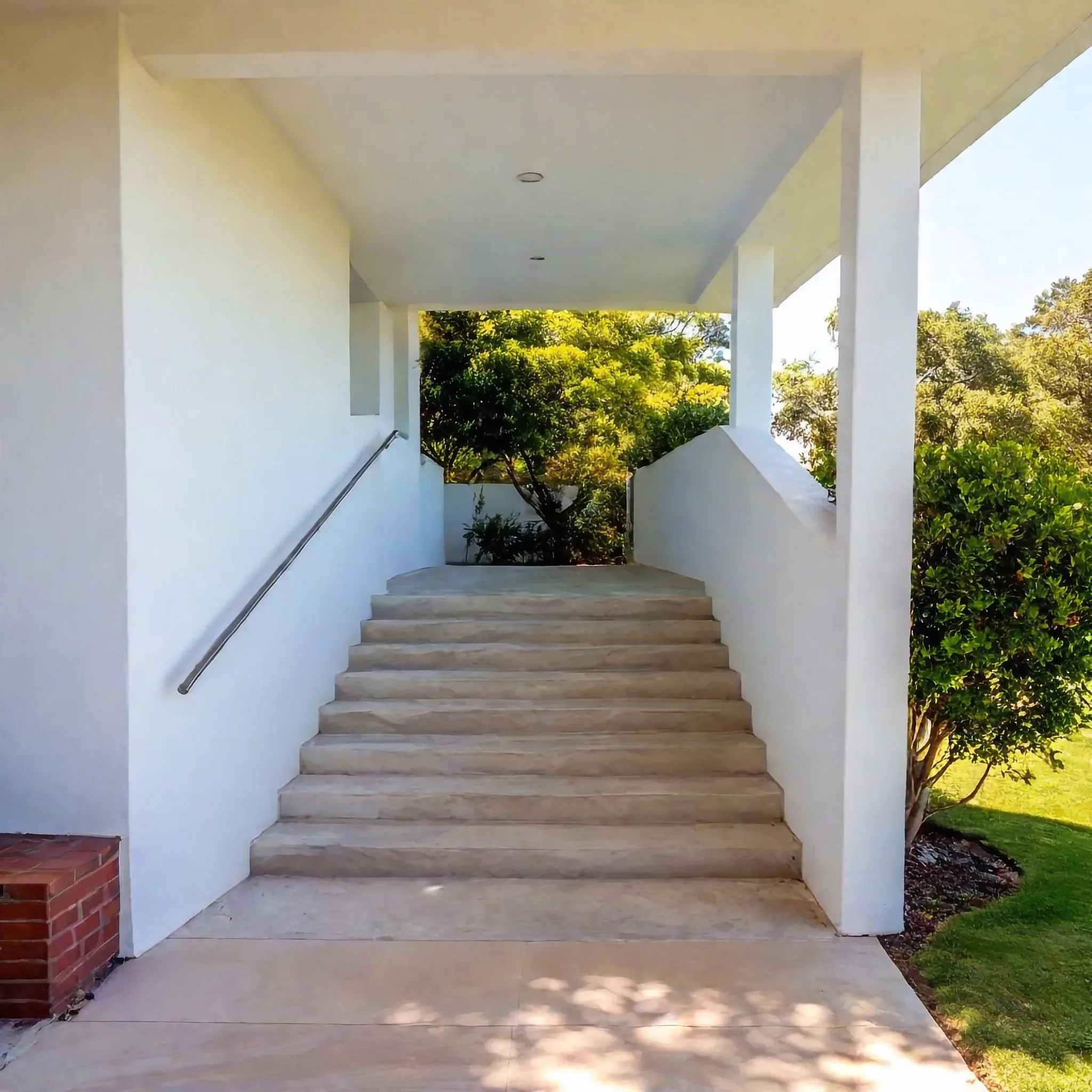 Concrete stairs leading to a covered entrance